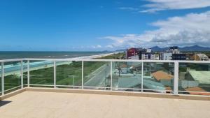 Elle comprend un balcon offrant une vue sur la plage et l'océan. dans l'établissement Studio Frente para o Mar - Matinhos, à Matinhos