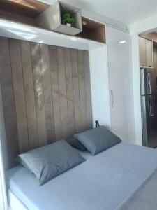 a bedroom with a white bed with a wooden headboard at Studio Frente para o Mar - Matinhos in Matinhos