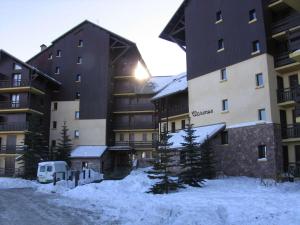 um grande edifício de apartamentos com neve em frente em Appartement Risoul, 1 pièce, 6 personnes - FR-1-330-506 em Risoul