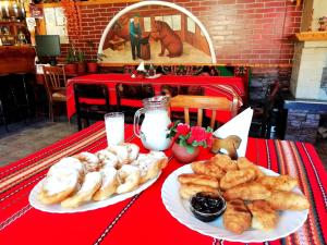 a red table with two plates of pastries on it at Kovacha Guest House in Raduil