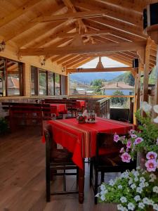 ein Esszimmer mit einem Tisch und einem roten Tischtuch in der Unterkunft Kovacha Guest House in Raduil