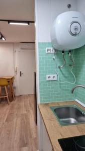 a kitchen with a sink and a green tile wall at Apartamento Luz de Luna Aguadulce in Aguadulce