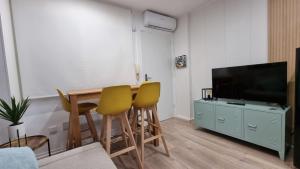 a living room with a table and chairs and a television at Apartamento Luz de Luna Aguadulce in Aguadulce