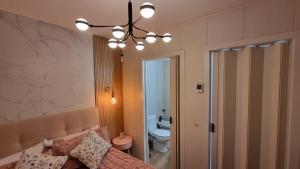 a bedroom with a couch and a chandelier at Apartamento Luz de Luna Aguadulce in Aguadulce