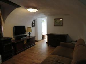 a living room with a couch and a television at Casa a Verdeggia in Triora