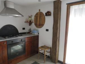 a kitchen with a stove and a chair in it at Casa a Verdeggia in Triora