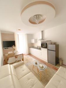 a living room with a white couch and a kitchen at Apartment #Story in Koper