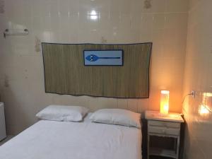 a room with a bed with a sign on the wall at Chalé Maluí Ubatuba in Ubatuba