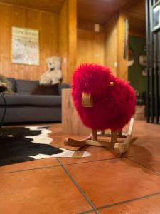 a red stuffed animal sitting on a chair in a room at Bel appartement près de Verbier in Bovernier