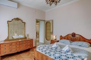 Schlafzimmer mit einem Bett, einer Kommode und einem Spiegel in der Unterkunft Bramante House - Intero Trilocale vicino alla Metro in Turin