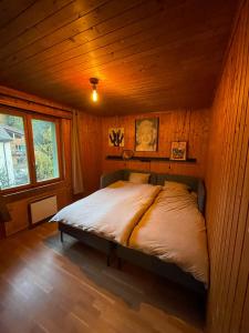 a bedroom with a bed in a wooden cabin at Bel appartement près de Verbier in Bovernier