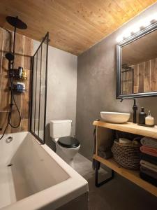 a bathroom with a tub and a toilet and a sink at Bel appartement près de Verbier in Bovernier