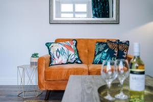 a living room with a couch and a table with wine glasses at Westwood Lodge Serviced Apartment in Coventry