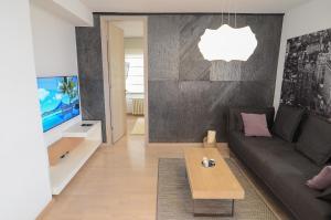 Una sala de estar con un sofá y un televisor. en Luna Deluxe Apartment & Free Parking, en Sarajevo