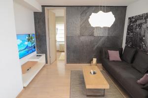 a living room with a couch and a tv at Luna Deluxe Apartment & Free Parking in Sarajevo