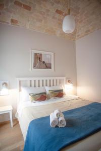 een slaapkamer met een bed met handdoeken erop bij Sistò Petite Maison in Altamura