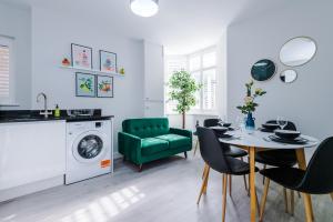 uma sala de estar com uma mesa e uma cadeira verde em Beechwood Lodge Serviced Apartment em Coventry