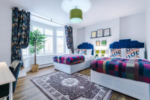 a bedroom with two beds and a rug at Beechwood Lodge Serviced Apartment in Coventry