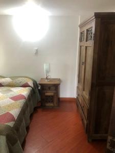 Un dormitorio con una cama y un tocador con una lámpara en una mesa. en HACIENDA MONCORA CABAÑA LAGO p 1, en El Rosal