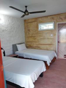 a bedroom with two beds and a ceiling fan at El Remanso del Santuario in Camarones