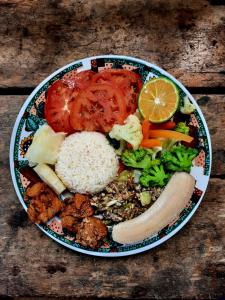 a plate of food with rice and vegetables on a table at La Muñequita Lodge 1 - culture & nature experience in Palmar Norte