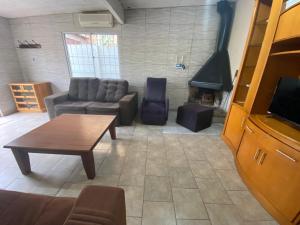 a living room with a couch and a table at Casa agradável com lareira in Chuí