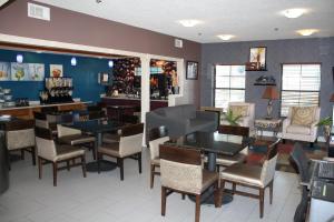 a restaurant with tables and chairs and a bar at Executive Inn and Suites Wichita Falls in Wichita Falls