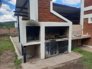 Hay un horno al aire libre fuera de un edificio. en Cabañas Lujan en El Volcán