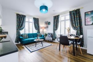 a living room with a blue couch and a table at Hearsall Place Serviced Apartment in Coventry