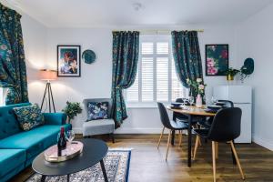 een woonkamer met een blauwe bank en een tafel bij Hearsall Place Serviced Apartment in Coventry