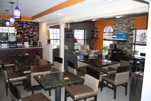 a restaurant with tables and chairs and a kitchen at Executive Inn and Suites Wichita Falls in Wichita Falls
