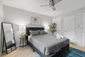 ein Schlafzimmer mit einem großen Bett und einem Spiegel in der Unterkunft Evonify Stays - Highland - Stylish Furnished Apartments in Austin