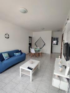 uma sala de estar com um sofá azul e uma mesa em Apartamento Coral em Santa Maria