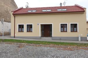 une petite maison avec un toit rouge et une allée. dans l'établissement Apartmány U Květné zahrady, à Kroměříž