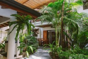 einen Innenhof mit Palmen in einem Haus in der Unterkunft Beach Heaven in Playa Guiones