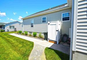 ein Haus mit einer weißen Tür und einem Rasenplatz in der Unterkunft Barge Road 13609 home in Ocean City