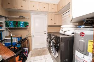 a small laundry room with a washer and dryer at Central Waterfront Villa Salt Wtr Pool Near Beach in Fort Lauderdale
