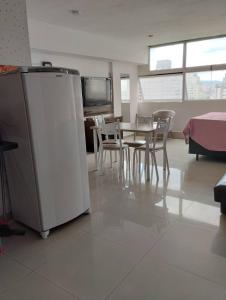 sala de estar con mesa y nevera en Loft Centro Histórico: Mirante, en São Paulo