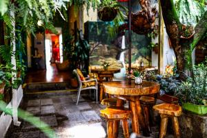 a restaurant with wooden tables and chairs and plants at Hostal The Garden Lleras 10 in Medellín