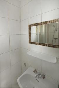 ein weißes Badezimmer mit einem Waschbecken und einem Spiegel in der Unterkunft Haus Deiser in Kappl