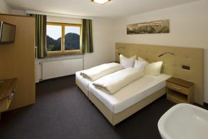 a bedroom with a white bed and a sink at Haus Deiser in Kappl