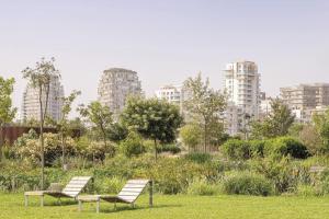 Deux chaises dans un parc avec des bâtiments en arrière-plan dans l'établissement A 2 minutes de Casa Finance City, appartement avec 2 Chambres, à Casablanca