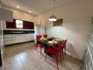 a kitchen with a table and chairs and a refrigerator at Condomínio Oasis das Flores in Porto De Galinhas