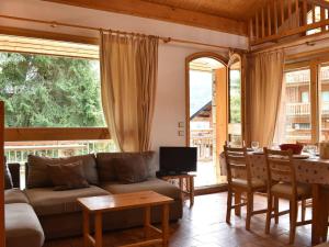 un soggiorno con un divano e un tavolo di Chalet cosy 6 pers. à 100m des pistes avec garage fermé et parking, Méribel - FR-1-180-411 a Les Allues