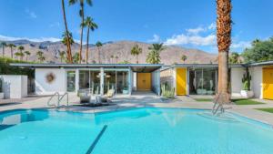 a swimming pool in front of a house at Limon Palm Springs A Luxury Boutique Hotel in Palm Springs