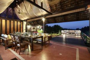 a dining room with a table and chairs on a deck at Vanilla hill (hill lodge) in Ban Muang Ha