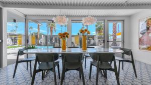a dining room with a glass table and chairs at Limon Palm Springs A Luxury Boutique Hotel in Palm Springs