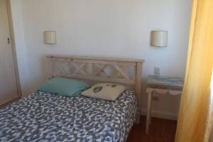 Dormitorio pequeño con cama y mesa auxiliar en Petit depto en mar del plata en Mar del Plata