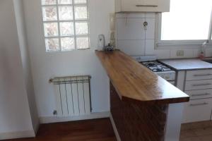 a kitchen with a wooden counter top and a stove at Petit depto en mar del plata in Mar del Plata