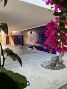 um quarto com uma parede de tijolos e flores cor-de-rosa em Blue Villa Zanzibar em Pwani Mchangani